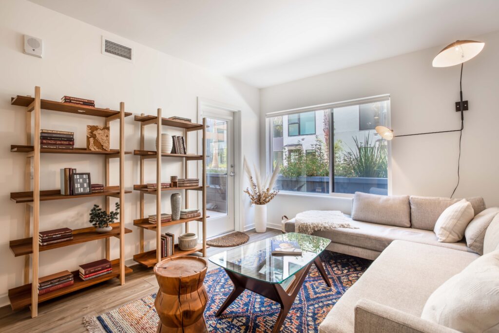 Model unit living area with white sofa and bookselves